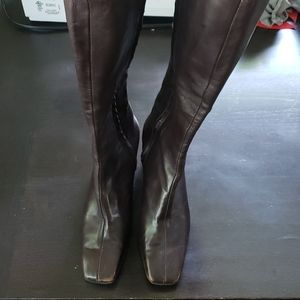 Knee high dark brown leather boots.